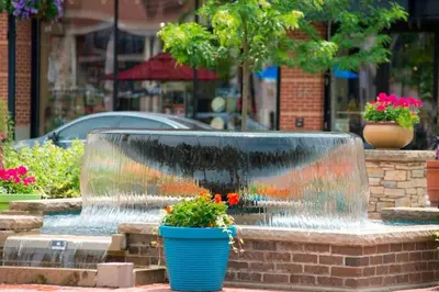 a water fountain with a blue pot with flowers in it at Towneplace Suites by Marriott Cleveland Westlake in Westlake