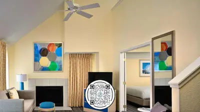 a living room with a ceiling fan and a bedroom at Sonesta Simply Suites Dublin Columbus in Dublin