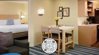 a hotel room with a bed and a table and chairs at Sonesta Simply Suites Dublin Columbus in Dublin