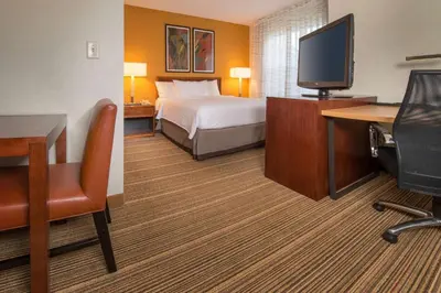 a hotel room with a bed and a flat screen tv at Sonesta ES Suites Charleston in Charleston