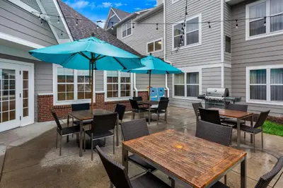 a patio with tables and chairs and umbrellas at Sonesta ES Suites Charleston in Charleston
