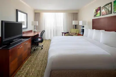 a hotel room with a large bed and a television at Charleston Marriott Town Center in Charleston