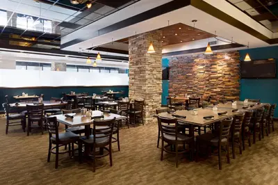 a dining room with tables and chairs and a brick wall at Charleston Marriott Town Center in Charleston