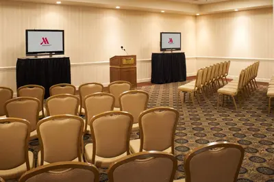 a conference room with chairs and a podium and a screen at Charleston Marriott Town Center in Charleston