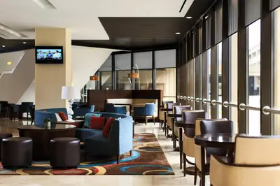 a lobby with chairs and tables and a television at Charleston Marriott Town Center in Charleston