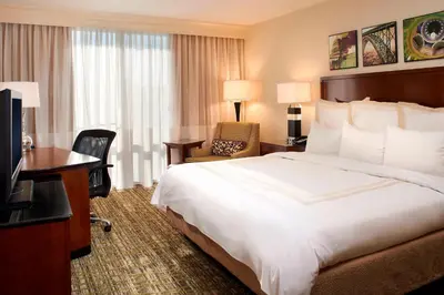 a hotel room with a bed and a desk and a television at Charleston Marriott Town Center in Charleston