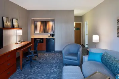 a hotel room with a couch and a desk at Courtyard Cincinnati Blue Ash in Blue Ash