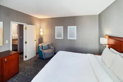 a hotel room with a bed and a chair at Courtyard Cincinnati Blue Ash in Blue Ash
