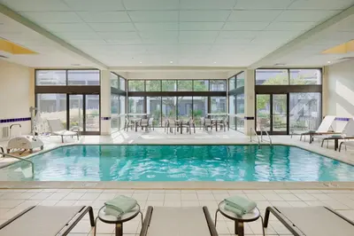 a large pool with chairs and tables in a building at Courtyard Cincinnati Blue Ash in Blue Ash