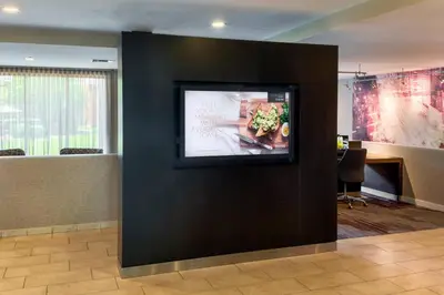 a flat screen tv on a black wall in an office at Courtyard Cincinnati Blue Ash in Blue Ash