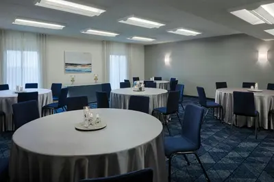 a room with several tables and chairs and tablesktop at Courtyard Dayton South Mall in Miamisburg