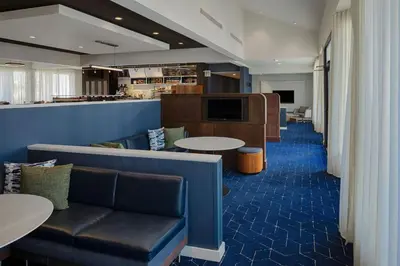 a waiting room with a couch and tables and a counter at Courtyard Dayton South Mall in Miamisburg