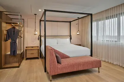 a bedroom with a canopy bed and a chair at Marriott Lexington Griffin Gate Golf Resort & Spa in Lexington