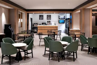 a restaurant with tables and chairs and a kitchen at Marriott Lexington Griffin Gate Golf Resort & Spa in Lexington