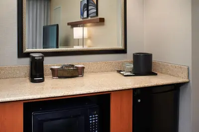 a bathroom with a counter with a microwave and a mirror at Courtyard by Marriott Lexington North in Lexington