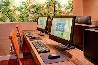 a desk with two computer monitors and a keyboard and mouse at Courtyard by Marriott Lexington North in Lexington