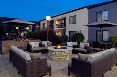 a patio with a fire pit with chairs and tables at Courtyard by Marriott Pittsburgh Airport in Coraopolis