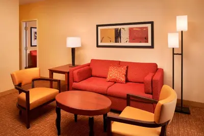 a living room with a red couch and chairs at Courtyard Toledo Airport Holland in Holland