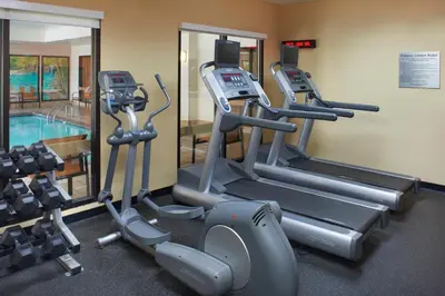 a gym with cardio machines and a swimming pool at Courtyard Toledo Rossford/Perrysburg in Rossford