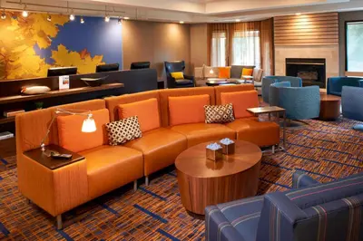 a lobby with a couch and tables and chairs at Courtyard Toledo Rossford/Perrysburg in Rossford