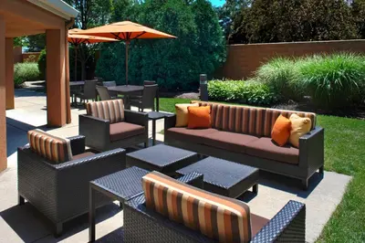 a patio with couches and tables and an umbrella at Courtyard Toledo Rossford/Perrysburg in Rossford