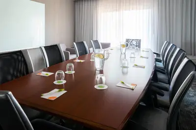 a conference room with a long wooden table with chairs at Courtyard Toledo Maumee/Arrowhead in Maumee
