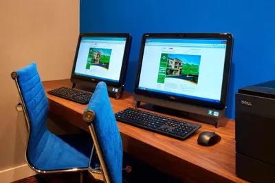 a desk with two computer monitors and a keyboard and mouse at Courtyard Toledo Maumee/Arrowhead in Maumee
