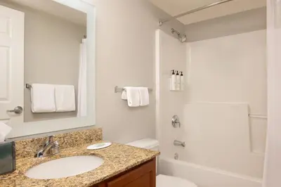 a white bathroom with a sink and a shower at TownePlace Suites by Marriott Findlay in Findlay