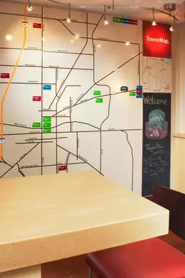 a table in a room with a wall with a map at TownePlace Suites by Marriott Findlay in Findlay