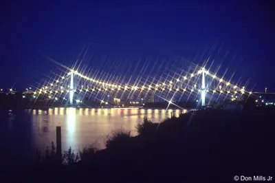 a lit up bridge over a river at night at TownePlace Suites by Marriott Findlay in Findlay