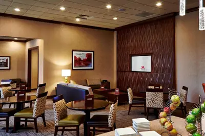 a restaurant with tables and chairs and a waiting room at Columbus Airport Marriott in Columbus