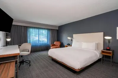 a hotel room with a bed and a desk at Courtyard Columbus Airport in Columbus