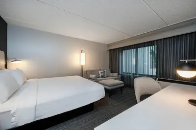 a hotel room with a bed and a chair at Courtyard Columbus Airport in Columbus