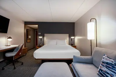a hotel room with a bed and a couch at Courtyard Columbus Airport in Columbus