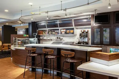 a bar in a restaurant with bar stools at Courtyard Columbus Airport in Columbus