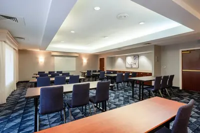 a conference room with tables and chairs at Courtyard Columbus Airport in Columbus