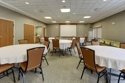 a conference room with tables and chairs and a whiteboard at SpringHill Suites Dayton South/Miamisburg in Miamisburg