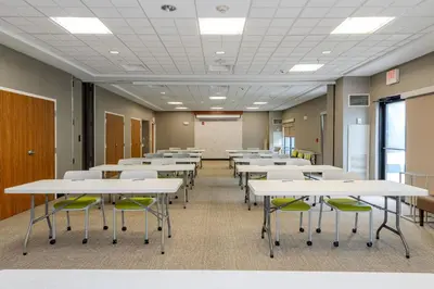 a classroom with white tables and green chairs at SpringHill Suites Dayton South/Miamisburg in Miamisburg