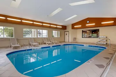 a pool in a hotel room with chairs around it at Comfort Suites Columbus Expo Center in Columbus