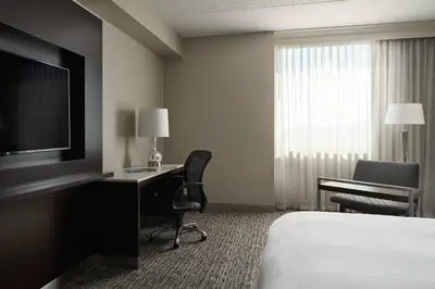 a hotel room with a bed and a desk and a television at Cleveland Marriott East in Warrensville Heights