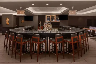 a bar with a table and chairs in a room at Cleveland Marriott East in Warrensville Heights