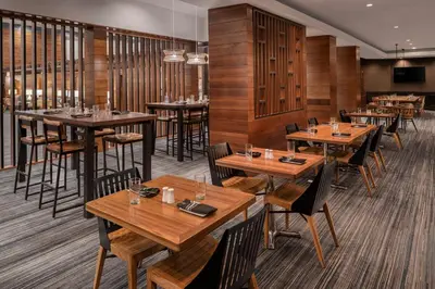 a dining room with wooden tables and chairs at Cleveland Marriott East in Warrensville Heights