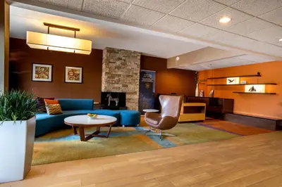 a living room with a blue couch and a table at Quality Inn & Suites Sandusky in Sandusky