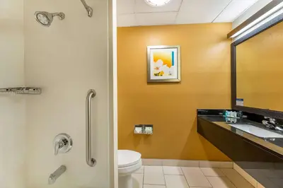 a bathroom with a toilet and a sink and a mirror at Quality Inn & Suites Sandusky in Sandusky