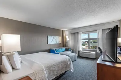 a hotel room with a bed and a chair and a window at Courtyard Columbus Easton in Columbus