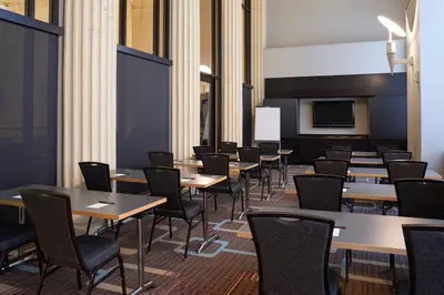 a dining room with tables and chairs and a tv at Residence Inn Columbus Downtown in Columbus