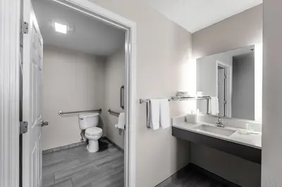 a bathroom with a toilet and a sink and a mirror at Residence Inn Columbus Easton in Columbus