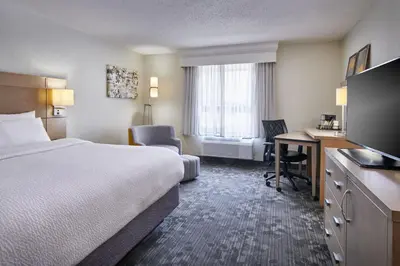 a hotel room with a bed and a desk at Courtyard Columbus Downtown in Columbus
