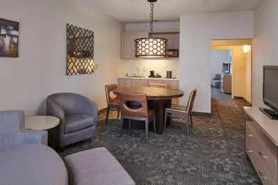 a living room with a table and chairs and a kitchen at Courtyard Columbus Downtown in Columbus