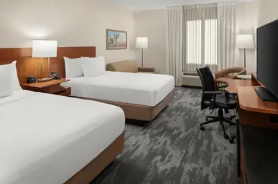 a hotel room with two beds and a desk at Fairfield Inn & Suites Columbus OSU in Columbus